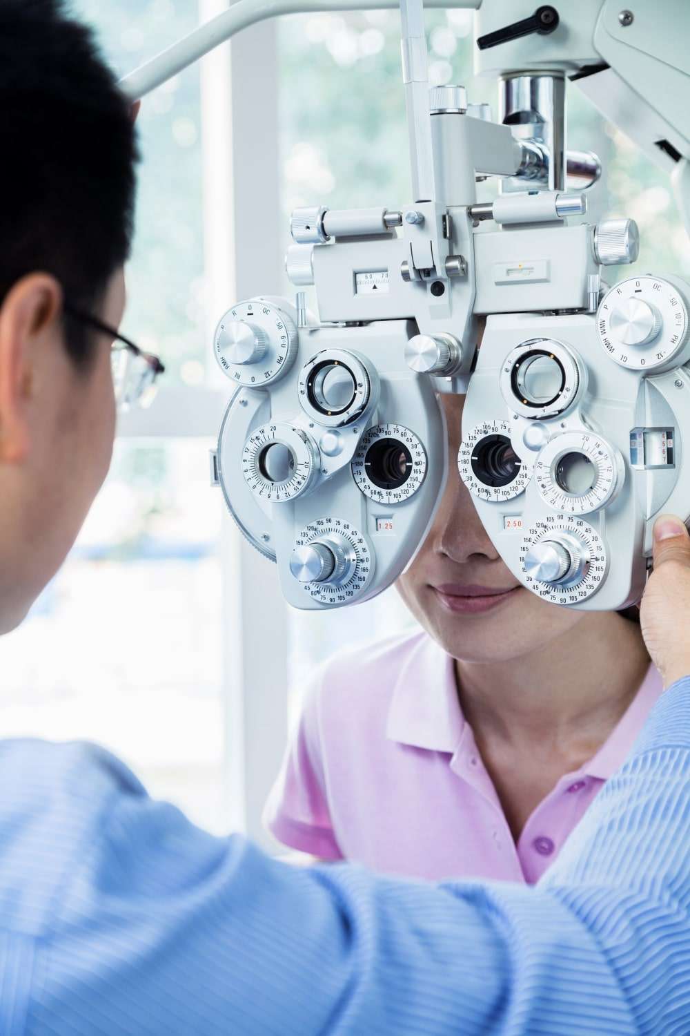 optometrist-doing-an-eye-exam-on-young-woman-2021-08-26-15-29-12-utc-min.jpg